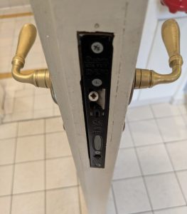 Pêne demi-tour bloqué à l'aide d'une vis cruciforme 
